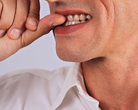 Close-up of man biting his fingernail