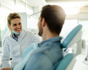 A hand holding an Invisalign aligner over an Invisalign case